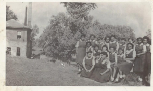 A vintage black and white group photo of girls at school