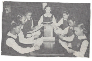 A vintage black and white picture of girls reading books